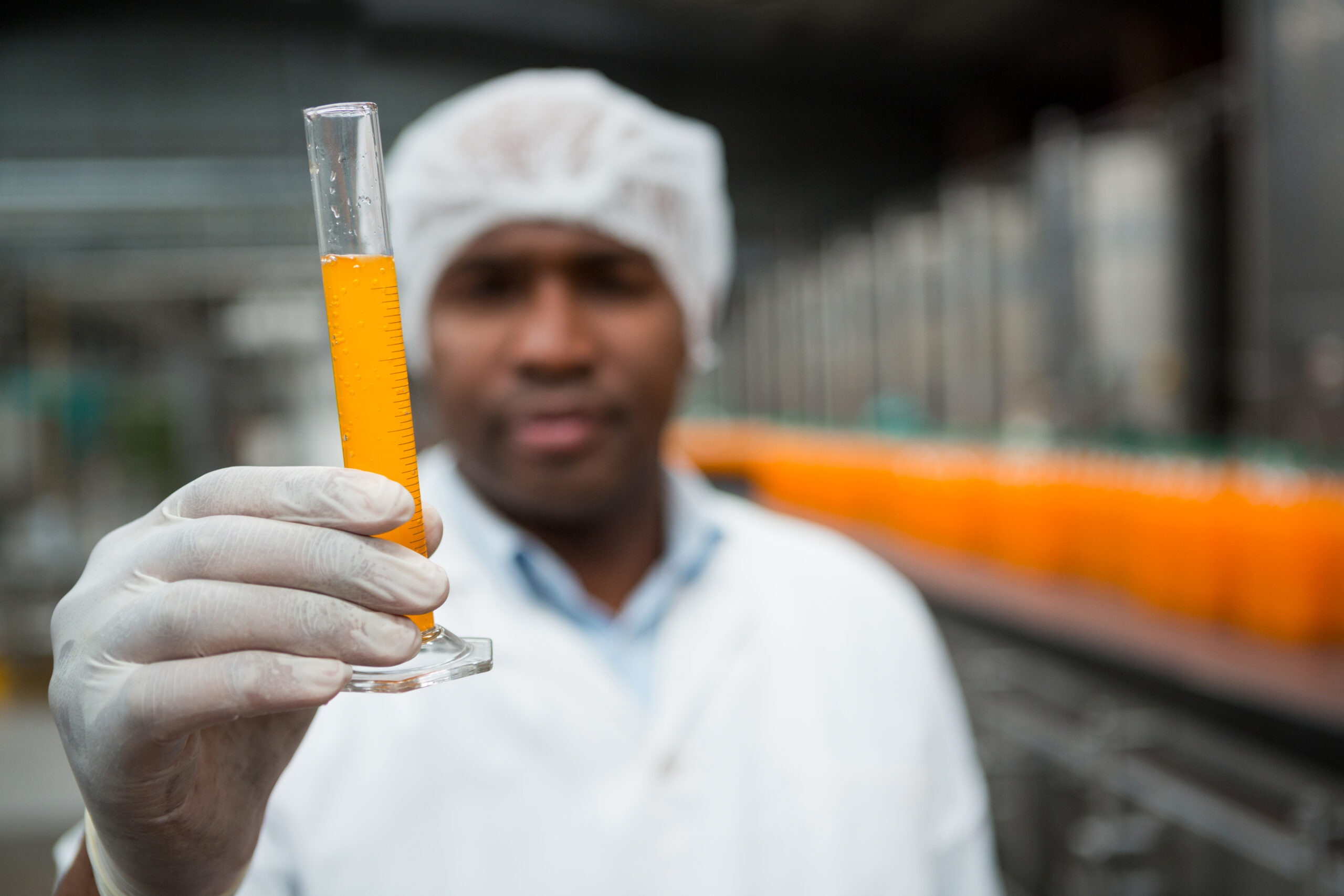 close up of male worker checking juice in factory